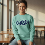 Woman wearing a light blue sweatshirt with 'CHosen' text in a modern cafe setting