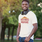 Man wearing a t-shirt with 'Faith Moves Mountains' in a park